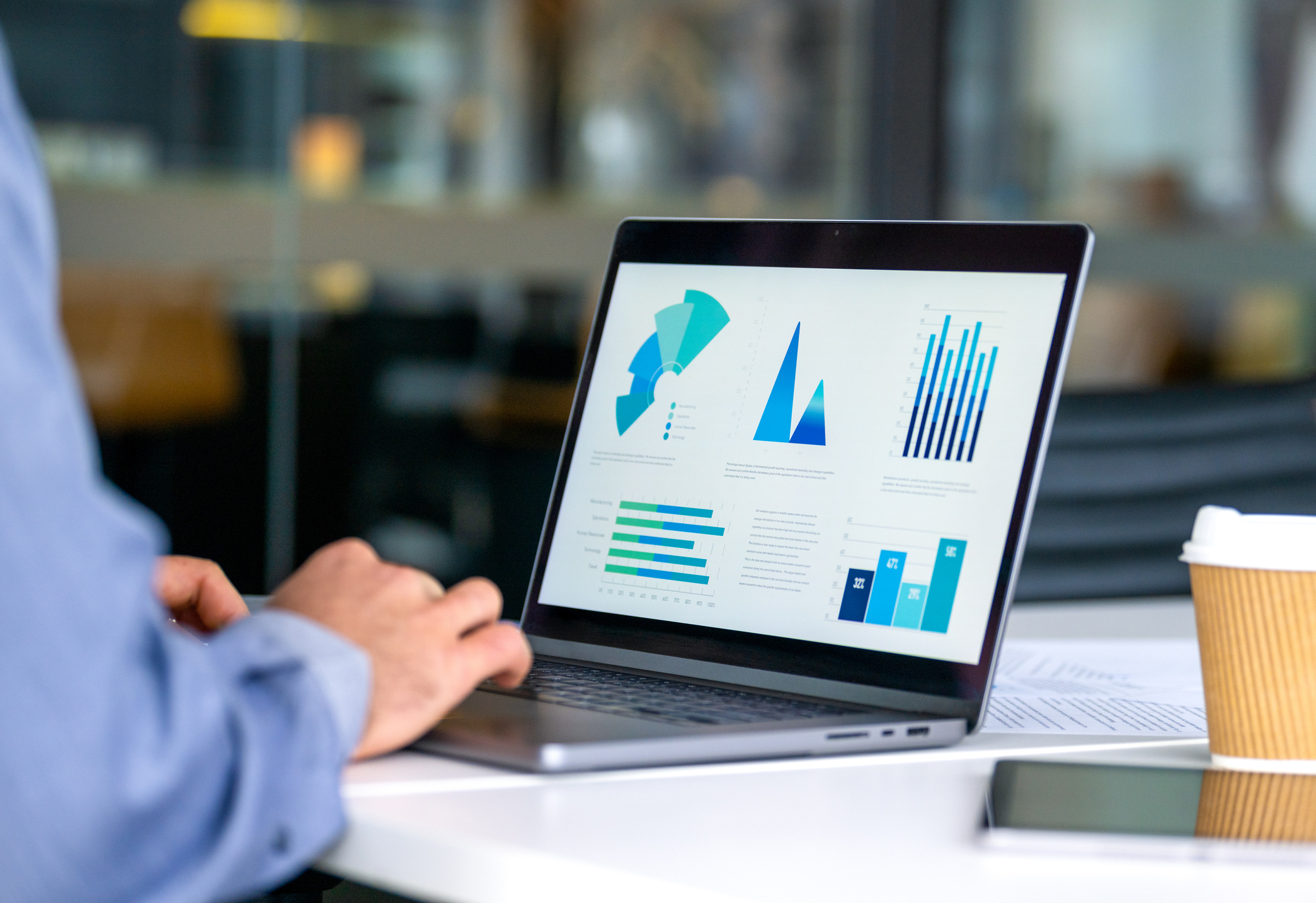 Close up of businessman using a laptop with graphs and charts on a laptop computer.